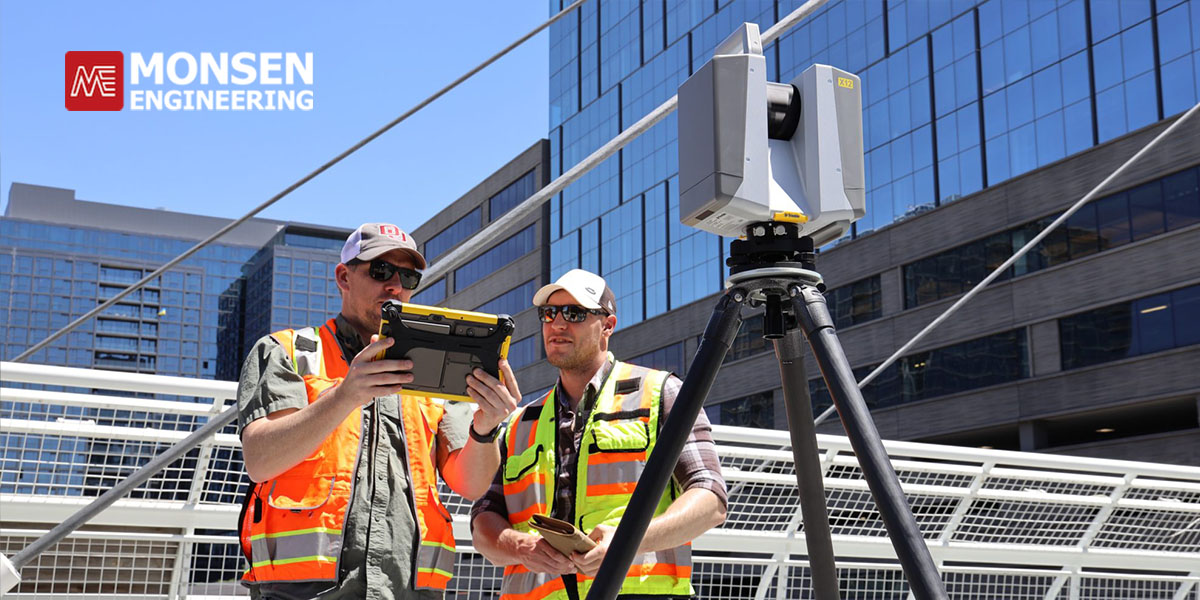 01-surveying-equipment-buyers-guide Two people with survey equipment near a building